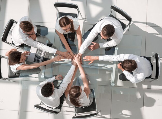 Vue de dessus des gens d'affaires avec leurs mains les unes sur les autres symbolisant le partenariat et l'esprit d'équipe