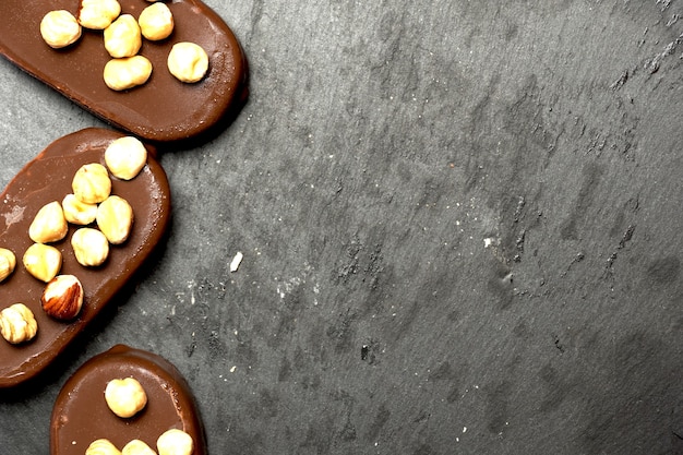 Vue de dessus des glaces au chocolat sur un fond d'ardoise sombre avec un design plat aux noisettes