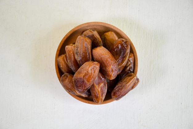 Vue de dessus gros plan de fruits de dattes séchées dans un bol pour ifthar ramadhan et ied fitr
