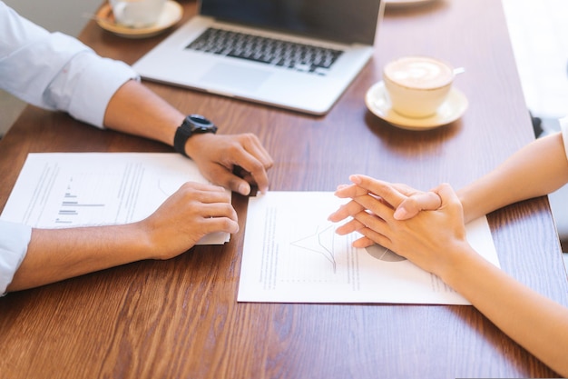 Vue de dessus en gros plan d'un homme d'affaires et d'une femme d'affaires méconnaissable discutant et vérifiant le papier