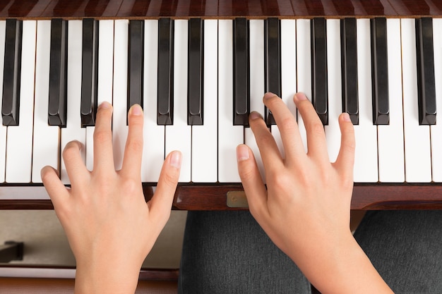 Vue de dessus gros plan des mains féminines jouant du piano