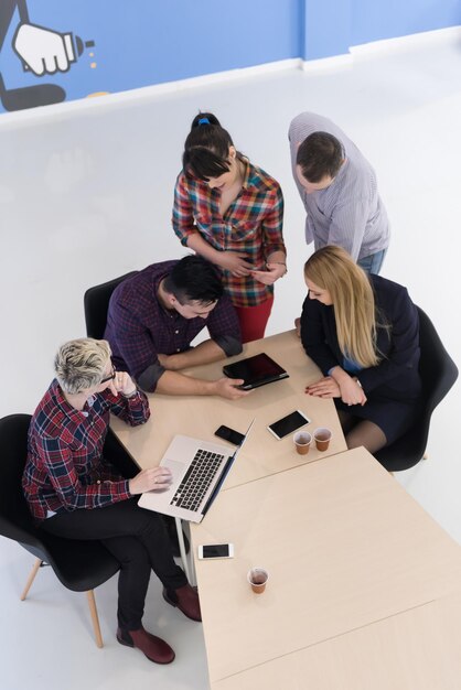 Vue de dessus d'un groupe de gens d'affaires multiethniques en démarrage lors d'une réunion de remue-méninges dans un intérieur de bureau moderne et lumineux