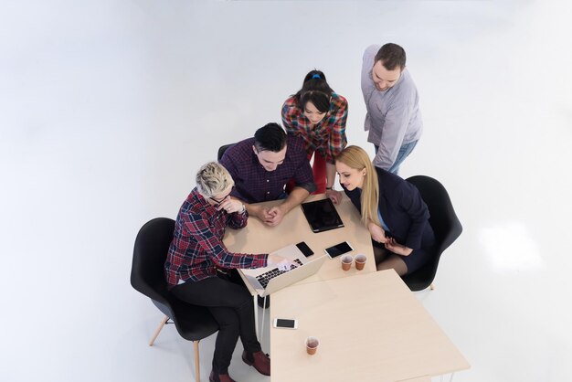 Vue de dessus d'un groupe de gens d'affaires multiethniques en démarrage lors d'une réunion de remue-méninges dans un intérieur de bureau moderne et lumineux