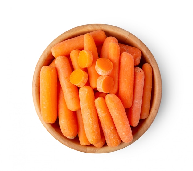 Vue de dessus d'un groupe de petites carottes biologiques dans un bol en bois isolé