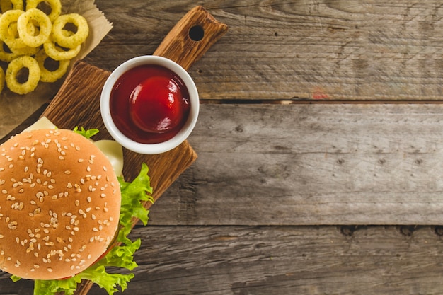 Vue de dessus de l&#39;hamburger avec des anneaux d&#39;oignons et de la sauce tomate