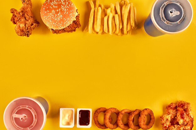 Photo vue de dessus hamburger frites et poulet frit sur fond jaune copiez l'espace pour votre texte