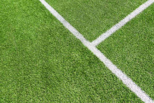 Vue de dessus de l'herbe verte de terrain de football de football artificiel avec ligne blanche