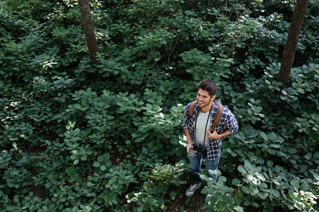 Vue de dessus de l'homme souriant en forêt