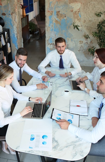 Vue de dessus des hommes d'affaires travaillant ensemble tout en passant du temps au bureau.