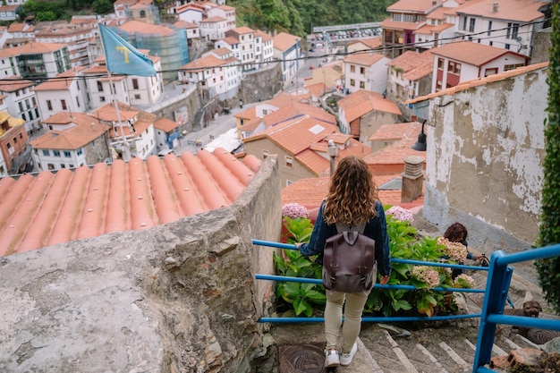 Vue de dessus horizontale d'une femme méconnaissable visitant une ville. Vue panoramique d'une femme voyageant dans la ville espagnole de Cudillero dans les Asturies. Personnes et destination de voyage dans le concept de l'Espagne.