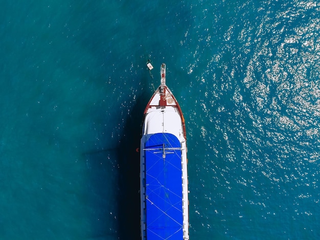 La vue de dessus d'un immense yacht blanc avec un toit bleu flotte sur la mer