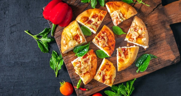 Vue de dessus des ingrédients de légumes de pizza faits maison sur un fond en bois noir