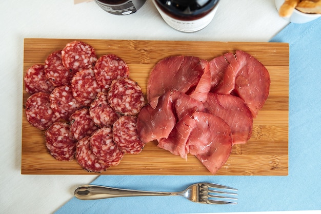 Vue de dessus sur le jambon espagnol et la saucisse fumée sur la planche de bois