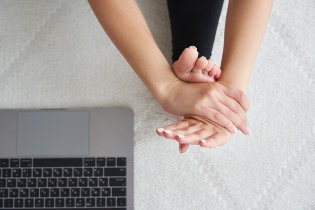 Vue de dessus d'une jeune femme pratiquant le yoga assise dans un exercice de flexion avant assis paschimottanasana