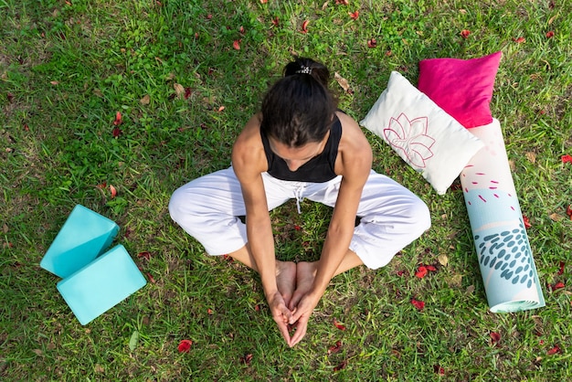 Vue de dessus d'une jeune femme pratiquant le yoga sur un pré vert en étirant les jambes Concept de bien-être