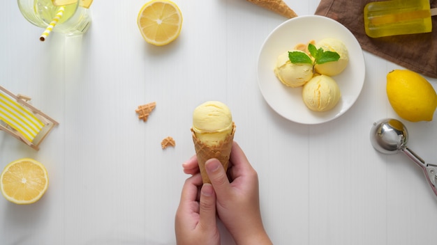 Vue de dessus d'une jeune fille tenant un cornet de crème glacée au citron