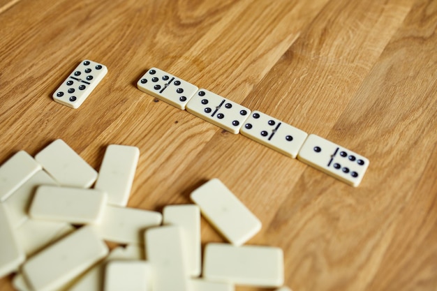 Vue de dessus des jeux de dominos blancs sur fond de table en bois avec concept de jeu de société espace copie