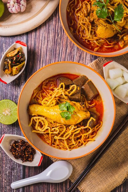 Vue de dessus de Khao Soi Kai Délicieuse cuisine du nord de la Thaïlande Arrangée avec des assaisonnements sur la table