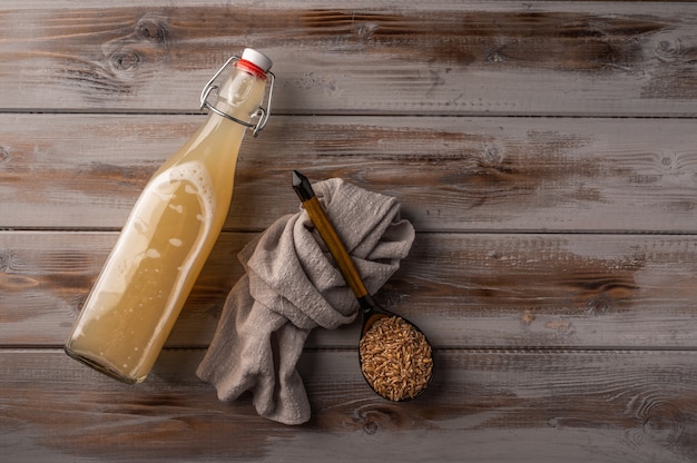 Vue de dessus kvass de seigle léger traditionnel russe en bouteille et serviette en lin sur bois