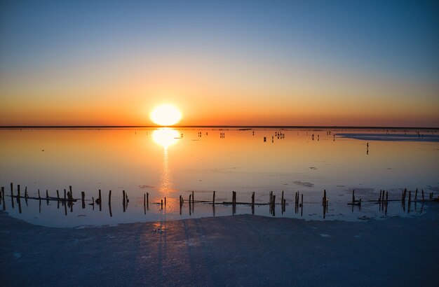 Vue de dessus d'un lac rose salé brillant et d'un chemin le long