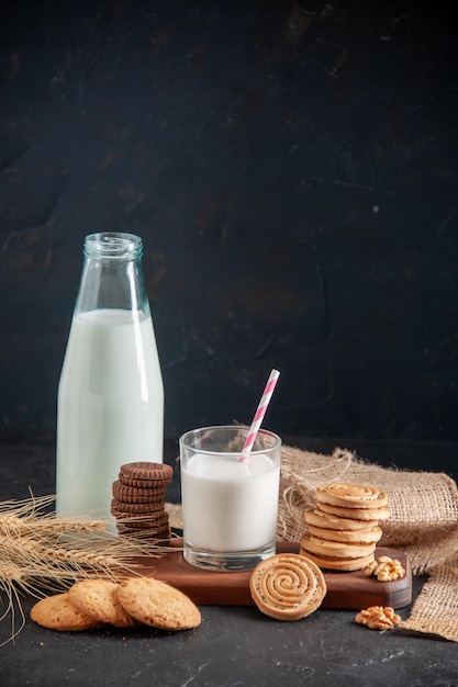 Vue De Dessus D'un Lait Frais Dans Un Verre Et Des Pointes De Biscuits En Bouteille Sur Une Planche De Bois Noix Cacahuètes Sur Fond Sombre