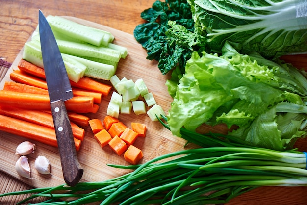 Vue de dessus de légumes ensemble de carottes et concombres en tranches, ail, oignon vert et laitue