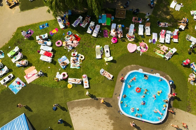 Vue de dessus d'un lieu extérieur pour se détendre où il y a une piscine et beaucoup de transats