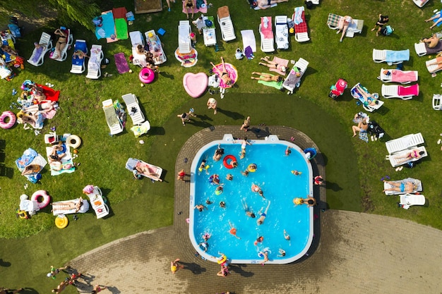 Vue de dessus d'un lieu extérieur pour se détendre où il y a une piscine et beaucoup de transats