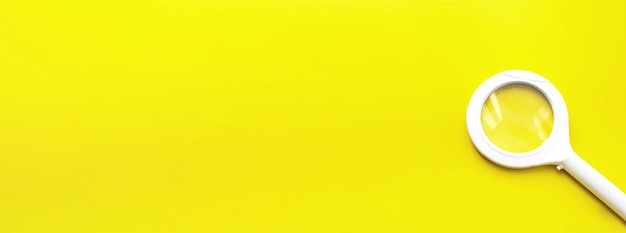 Vue de dessus d'une loupe unique avec poignée sur jaune avec ombre douce. Concept de recherche Internet.