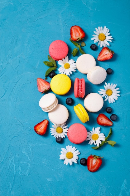 Vue de dessus sur les macarons, les fraises et la camomille