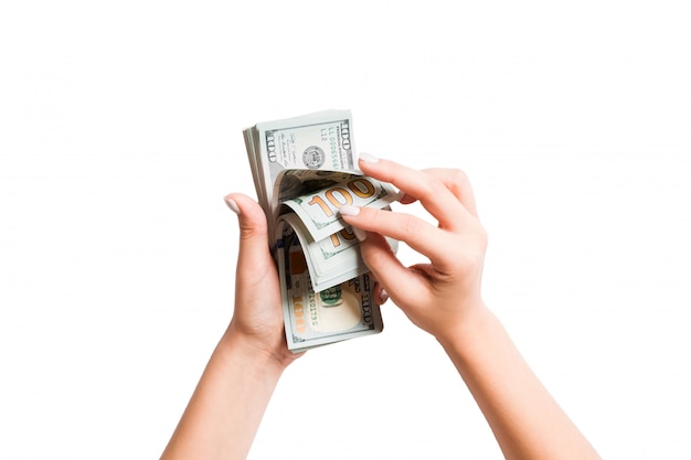Vue de dessus des mains féminines comptant des billets de dollar sur fond isolé blanc