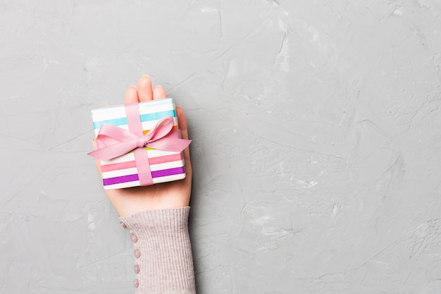 Vue de dessus des mains féminines tenant une boîte cadeau de Noël