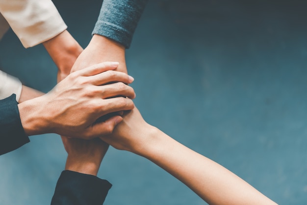 Photo vue de dessus les mains des hommes d'affaires se réunissent dans une pile de mains pour symboliser la collaboration, le travail d'équipe pour atteindre les objectifs et le succès.