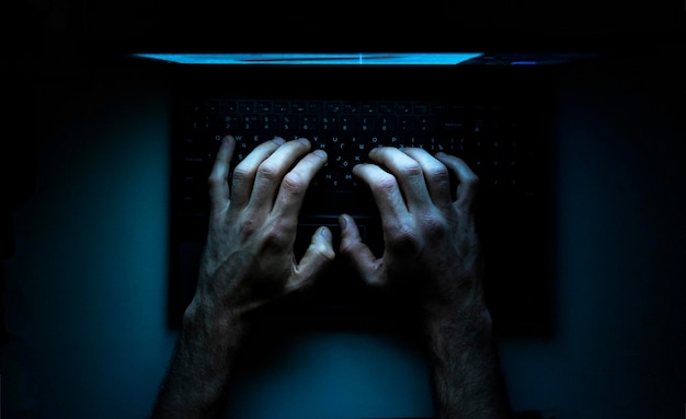Photo vue de dessus des mains d'un programmeur sur son ordinateur portable