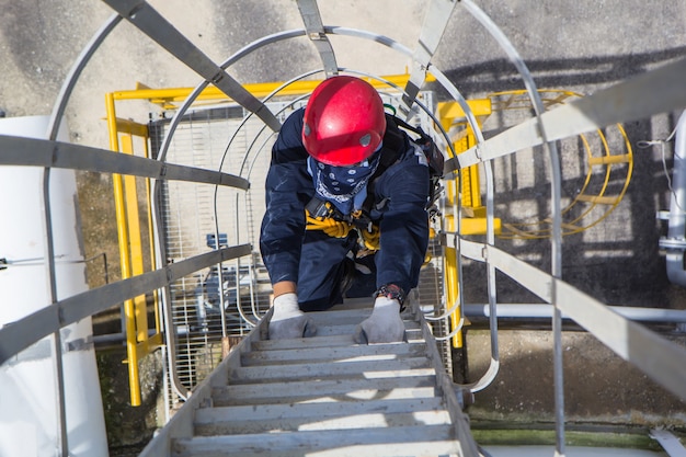 Vue de dessus mâle grimper le réservoir froid de stockage d'échelle