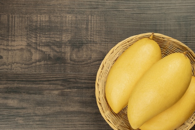 Vue de dessus de mangue fraîche. fond en bois et espace de copie pour ajouter du texte.