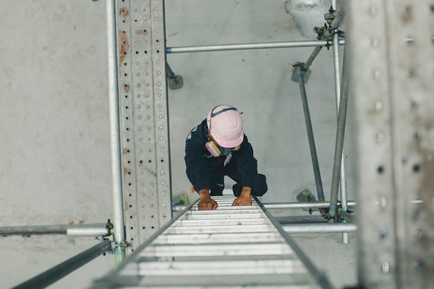 Vue de dessus masculine monter l'escalier de stockage d'échafaudage d'inspection visuelle de l'huile du réservoir