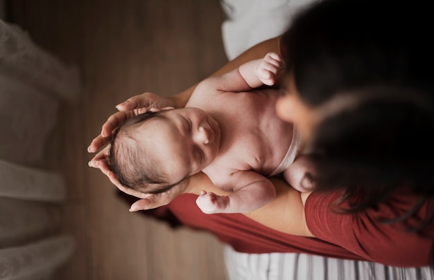 Photo vue de dessus mère tenant petit bébé