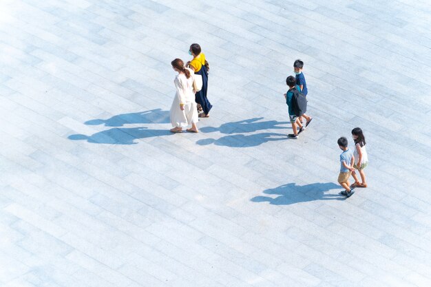 Vue de dessus des mères et des enfants de la famille du groupe marchant sur une passerelle piétonne en plein air