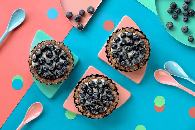 Vue de dessus sur les mini gâteaux à la crème aux myrtilles pour la fête d'anniversaire des enfants