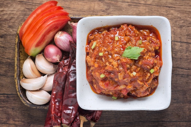 Vue de dessus de (Nam prik ong) Trempette épicée à la viande et à la tomate du nord de la Thaïlande dans une tasse blanche.