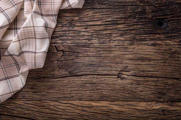 Vue de dessus de la nappe à carreaux ou de la serviette sur une table en bois vide.