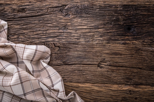 Vue de dessus de la nappe à carreaux ou de la serviette sur une table en bois vide.