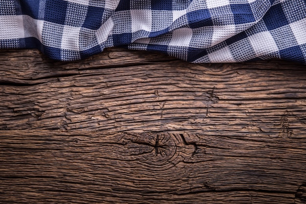 Vue de dessus de la nappe à carreaux ou de la serviette sur une table en bois vide.