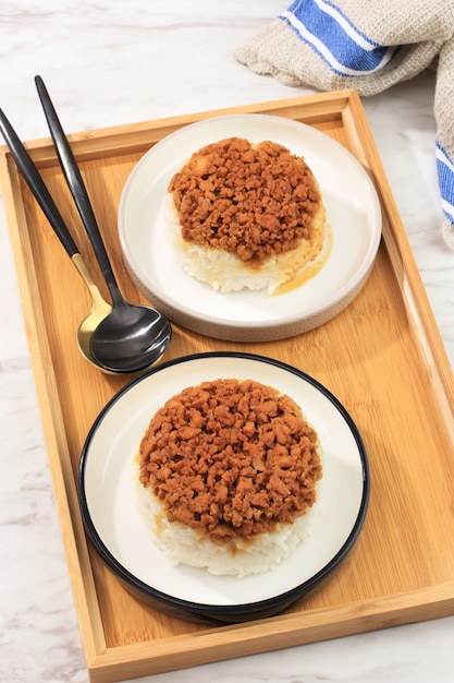 Vue de dessus Nasi Tim Ayam maison, riz cuit à la vapeur avec sauce soja au poulet en dés. Nourriture réconfortante indonésienne pour le petit-déjeuner. Servi sur plaque en céramique avec espace de copie pour le texte