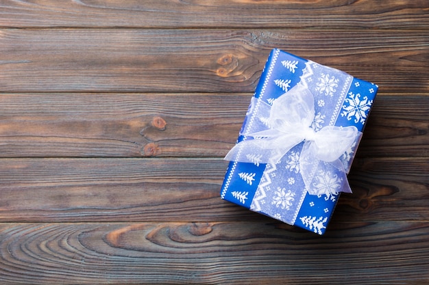 Vue de dessus Noël ou autre emballage de boîte présente à la main de vacances, fond plat en bois foncé. boite cadeau