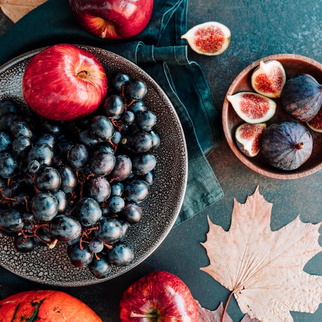 Vue de dessus de la nourriture d'automne à plat avec des fruits et légumes de saison comme les pommes et les figues rouges de raisin bleu de Bangalore sur une table