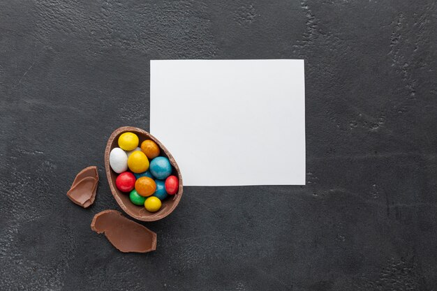 Vue de dessus de l'oeuf de Pâques au chocolat rempli de bonbons colorés