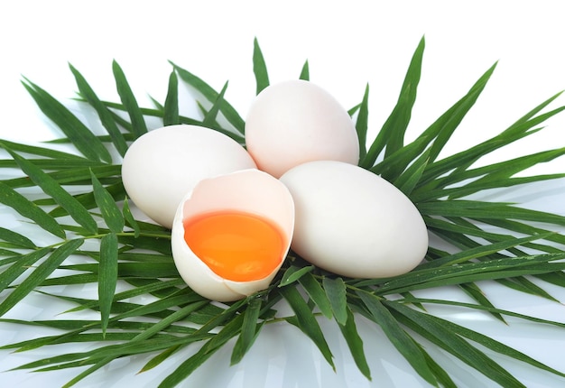 Vue de dessus des œufs de canard avec des feuilles de bambou sur fond blanc