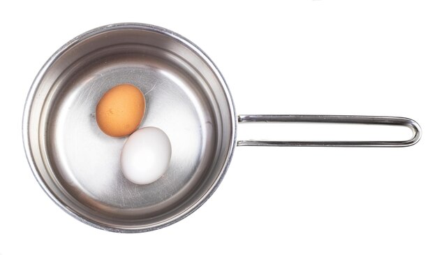 Vue de dessus des œufs dans une casserole avec de l'eau isolée